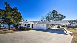 A single-story house with a covered porch, a driveway, and a view of the water. - Stunning Seneca Home w/ Lake Keowee Access! (Seneca)