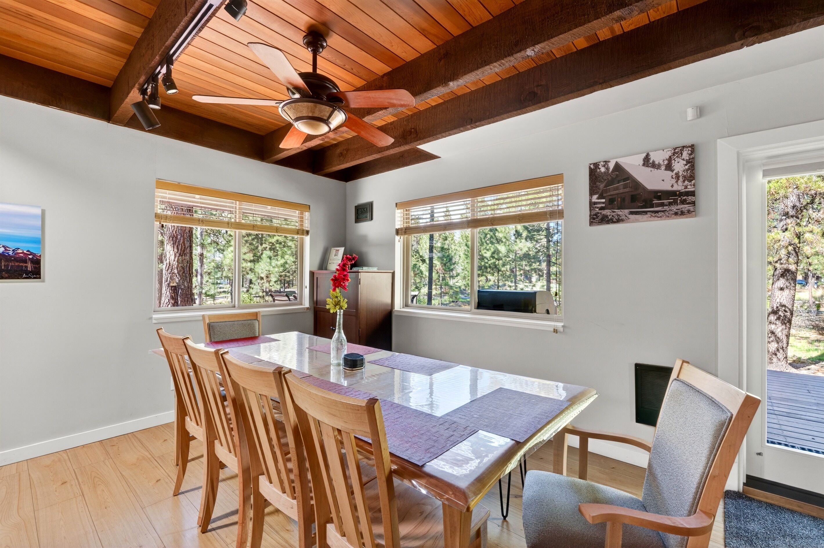 Un espace repas comprenant une table en bois, des chaises et un ventilateur de plafond.
