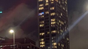 A tall, illuminated skyscraper with a pointed top, surrounded by other buildings. - Charming 2-bed Apartment in London (London)