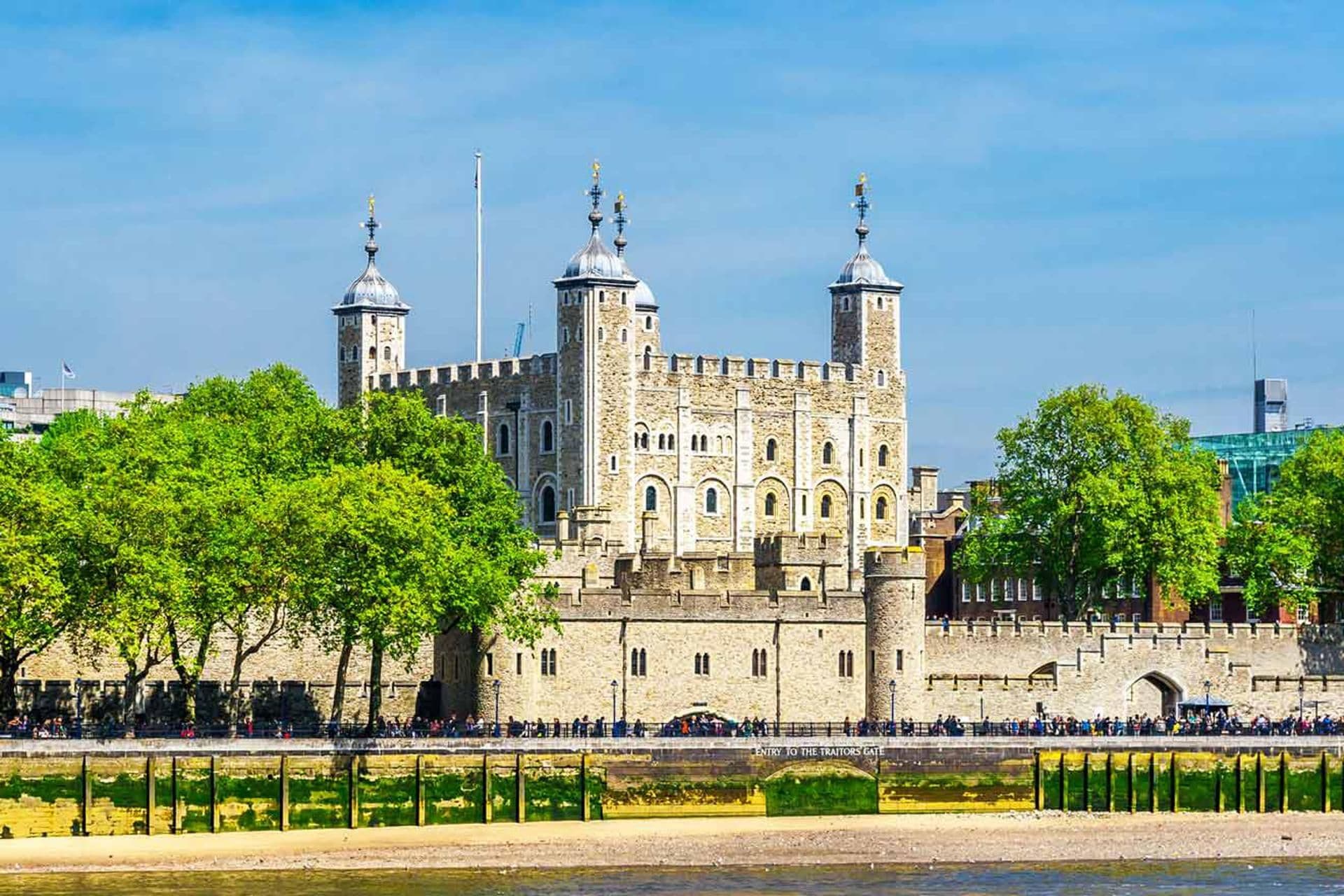 A historic castle with multiple towers, a moat, and a bridge leading to the entrance.