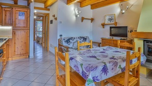 Ein gemütliches Zimmer mit Holzmöbeln, einem Bett mit floralem Überwurf, einem Fernseher und einem Kamin.