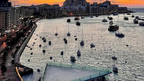 A waterfront hotel with a pool, boats, and a cityscape in the background. - Ewa Apt - 3-bed Near Sliema - St Julians Seafront (Gzira)