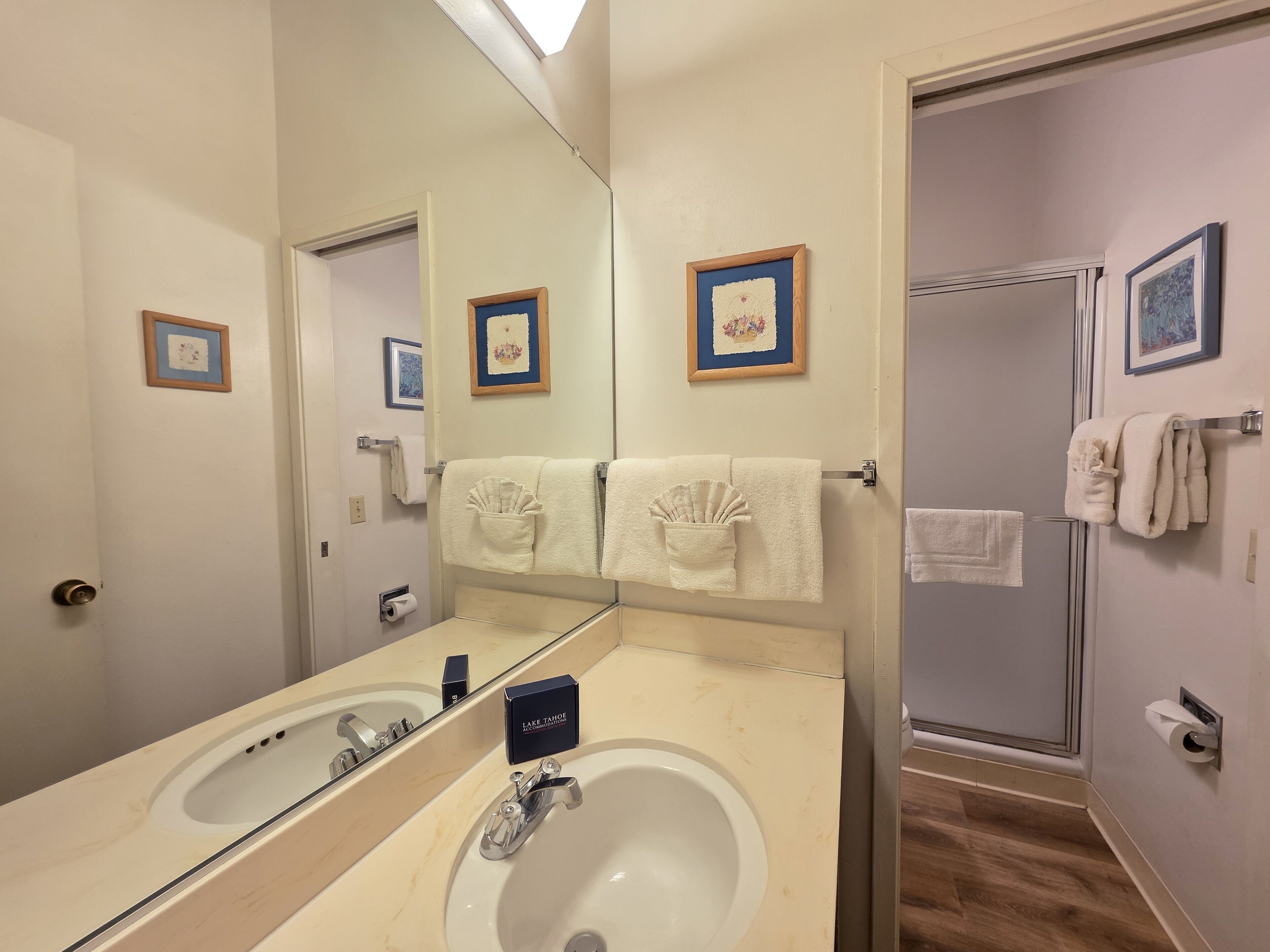Un baño con dos lavamanos, un espejo grande y una zona de ducha.