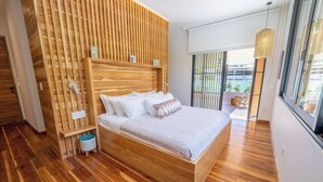 Un dormitorio moderno con cabecera de madera, una cama grande y vistas al exterior a través de un ventanal corredera.