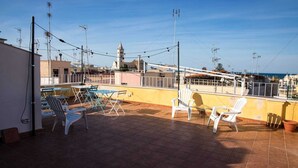 A rooftop terrace with outdoor seating and a view of the cityscape.