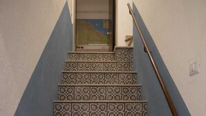 A staircase with ornate patterned tiles leading to a door.