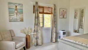 Une chambre à coucher avec un lit, une chaise, une fenêtre avec des rideaux, un radiateur et un tableau accroché au mur.