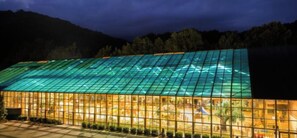 Ein Gebäude mit einer großen Glasfassade und einem Dach mit geometrischem Muster.