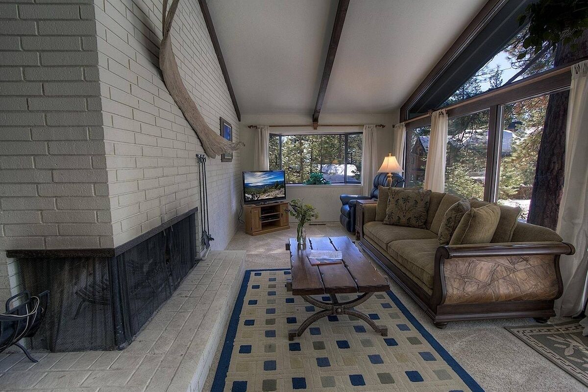 A living room with a fireplace, a sofa, a coffee table, and a television.