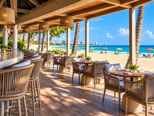 Un espace extérieur aménagé avec des meubles en osier et offrant une vue sur la plage.