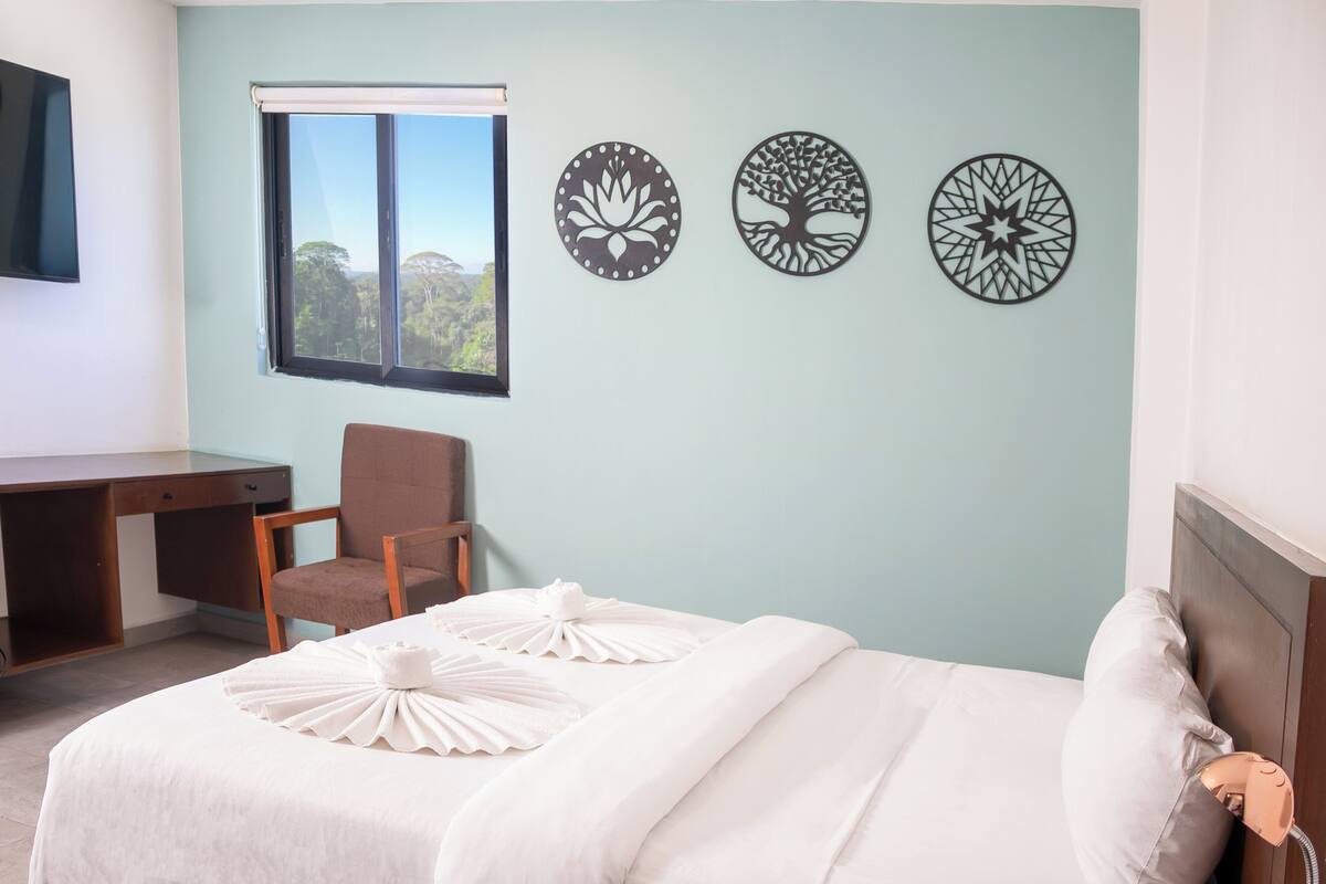 Une chambre à coucher comprenant un lit, un bureau, une chaise et deux éléments de décoration murale.