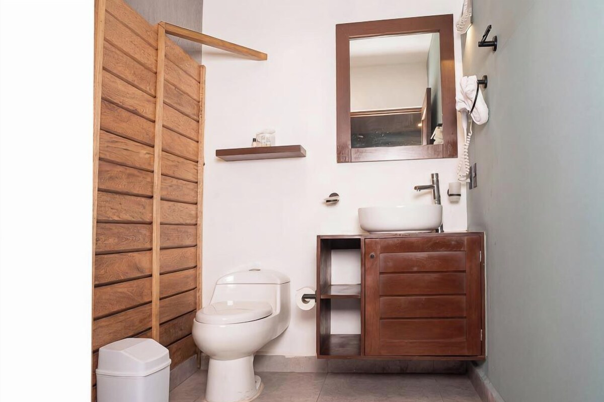 Une salle de bain avec un mur en bois, des toilettes, un lavabo et un miroir.