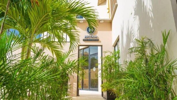 Entrada de hotel de diseño moderno, con puerta de vidrio y un cartel encima.