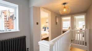 A staircase leading to a bedroom with a view of a brick wall and a window. - Trinity Cottage, Stratford-upon-Avon - sleeps 5 guests in 3 bedrooms (Stratford-upon-Avon)