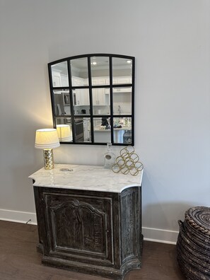 Kitchen features a large mirror, stainless steel appliances, and a wooden floor.