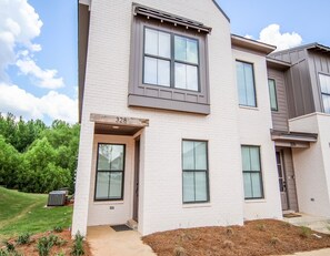 Stylish two-story home with a clean design, featuring a flat roof and symmetrical facade.