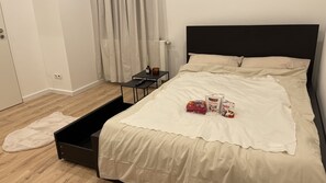 Cozy retreat with a neatly made bed, black headboard, and bedside table.