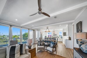 A spacious living area with a large window, ceiling fan, and a view of the outdoors.