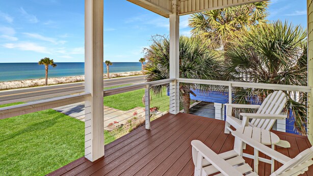 A wooden deck with white chairs and a view of the beach and ocean. - Living the Dream MB: 4th of July week available as a Friday or Saturday check in (Mexico Beach)