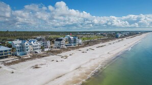 A coastal area with beachfront properties, including multi-story houses with balconies and a beach in the foreground. - Margar-et Away: Lovely 6BR Home on SJB- Sleeps 20, Priv. Pool, Beachfront! (St. Joe Beach)