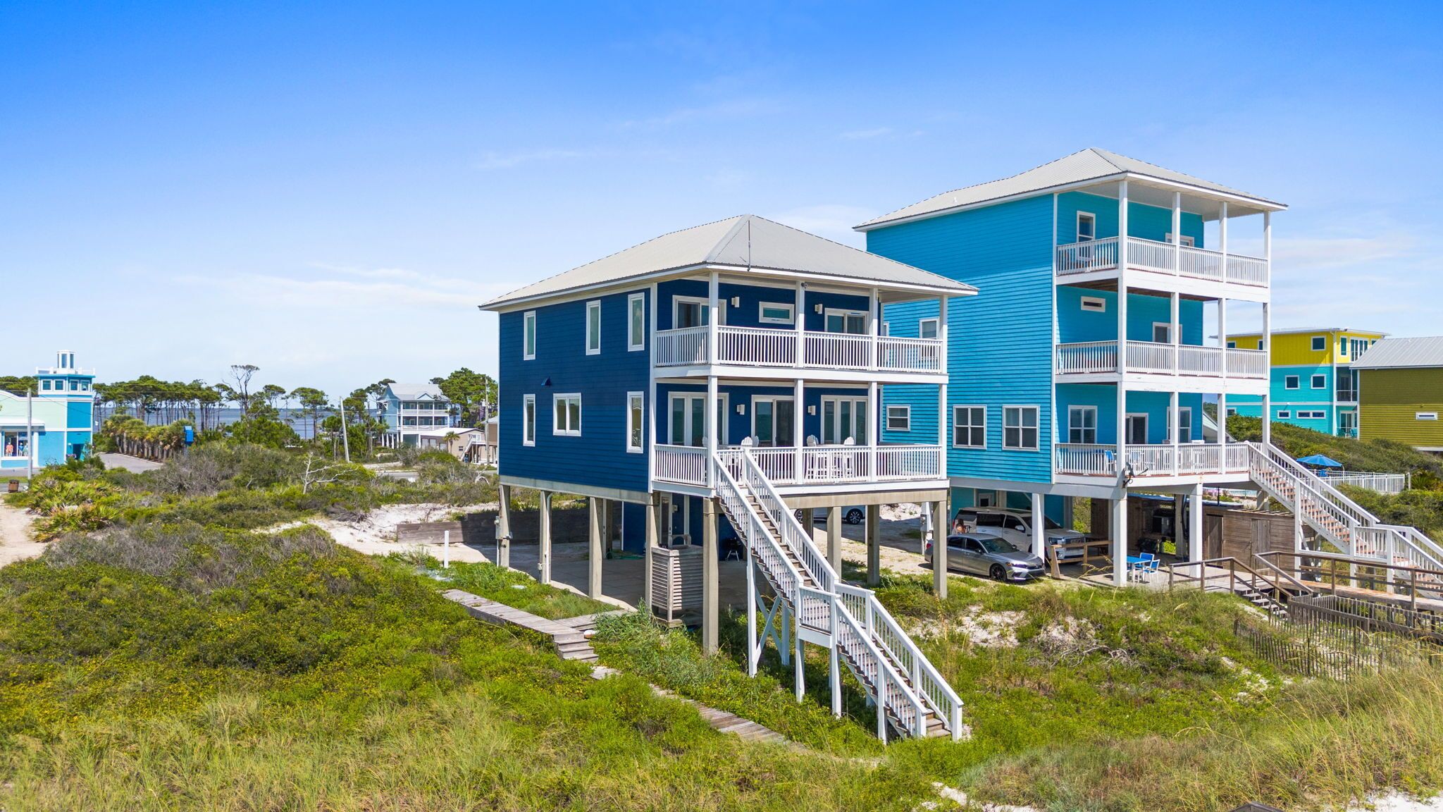 A multi-story beachfront building with balconies and a staircase leading to the upper levels.