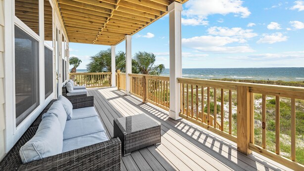 A covered deck with outdoor seating and a view of the ocean. - Memory Maker: Beachfront, Fire Pit, Sleeps 18! (St. Joe Beach)