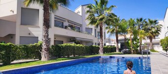 Top floor apartment with sunny roof terrace, heated pool and garden