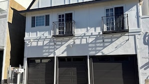 Een huis met twee verdiepingen, een garage, een balkon en een klein raam.