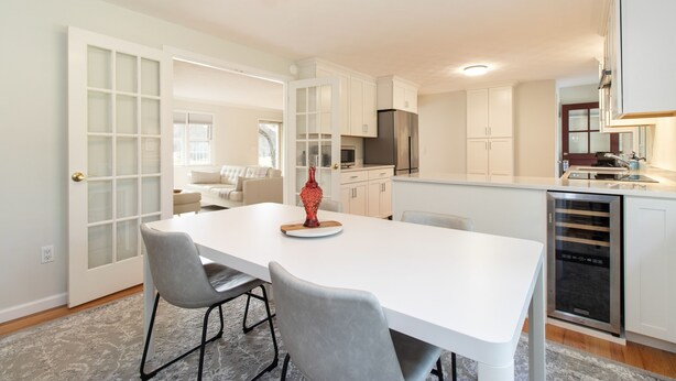 A modern kitchen with white cabinetry, a central island with seating, and a built-in dishwasher. - Recently Updated, One Level, Attached Garage, Peaceful, Zen-Minimalist Space.  (Avon)
