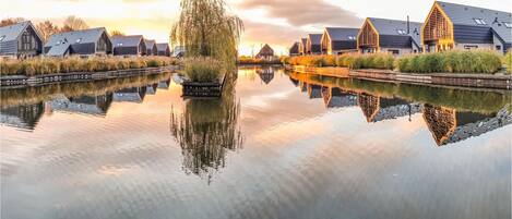 Una vista tranquila del río con edificios modernos reflejándose en el agua serena.