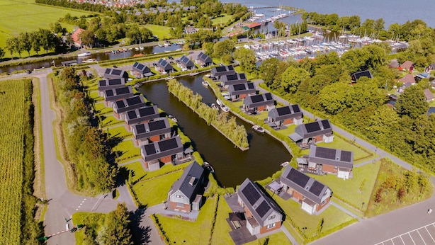 A residential area with houses arranged around a central canal, connected by pathways. - Lovely home in Balk with kitchen (Balk)