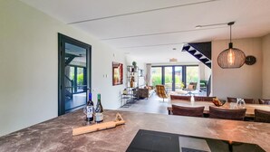 A modern kitchen with a marble countertop, wine bottles, and a built-in range hood. - Lovely home in Balk with kitchen (Balk)
