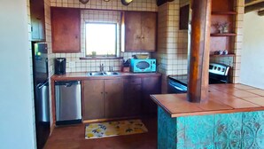 Una cocina con armarios de madera, microondas, fregadero y lavavajillas.