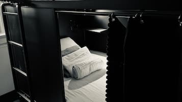 A bunk bed with a lower bed and a top bunk, both with white bedding.