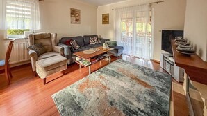 A living room with a sofa, armchair, coffee table, and a TV. - 2 bedroom amazing home in Parzensko (Parzensko)