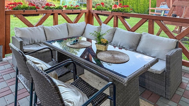 A wicker outdoor seating area with a glass table, cushioned chairs, and a wooden deck. - 2 bedroom amazing home in Parzensko (Parzensko)