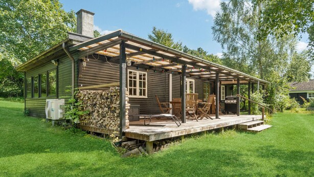 A rustic cabin with a wooden deck, a chimney, and a grill. - 2 bedroom amazing home in Jægerspris (Jægerspris)