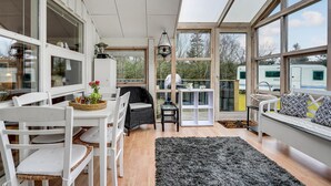 A modern, open-plan living space with a dining area, a seating area with a sofa, and a kitchen. - Lovely home in Hals with kitchen (Hals)