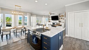 Una cucina moderna con isola centrale, forno integrato e zona pranzo con tavolo e sedie.
