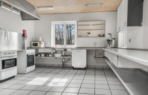 Modern kitchen with stainless steel range hood, microwave, toaster oven, and appliances.
