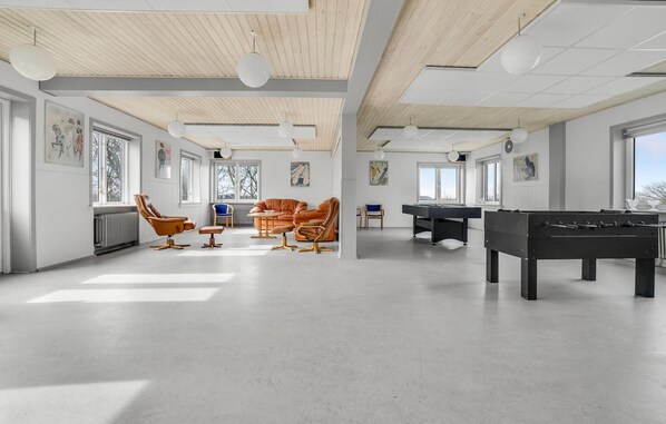 Relax in this stylish room with leather armchairs, a sofa, and foosball tables.