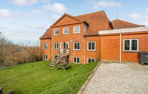 Stroll up the gravel driveway to this charming two-story home, featuring a spacious staircase and large windows.