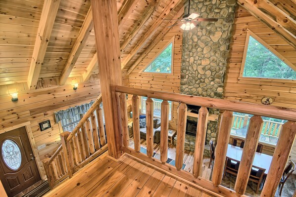 Un intérieur en bois avec un mur en pierre, des poutres en bois au plafond et une vue sur un patio extérieur.