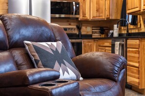Un fauteuil en cuir marron avec un coussin à motifs, dans une cuisine.
