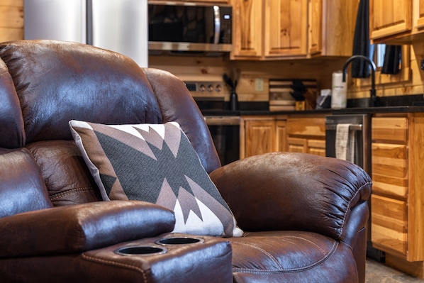 A brown leather armchair with a patterned pillow in a kitchen setting.