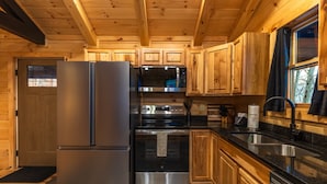 Une cuisine moderne dotée d’appareils électroménagers en acier inoxydable, d’armoires en bois et d’un plan de travail en granit.