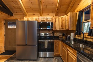 Eine moderne Küche mit Edelstahlgeräten, Holzschränken und einer Arbeitsplatte aus Granit.