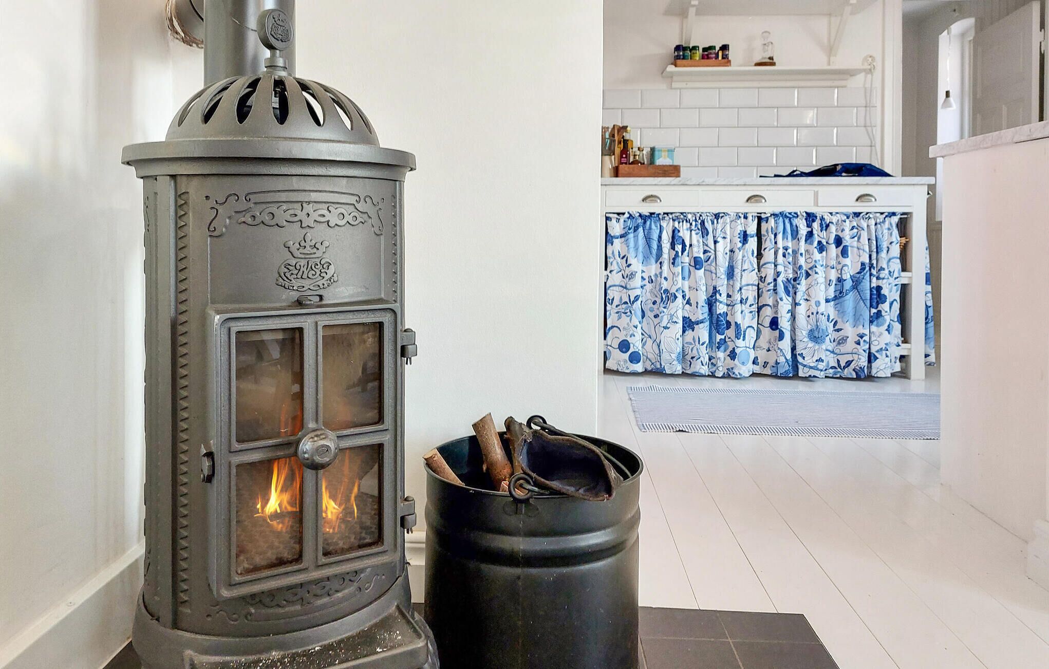 A wood-burning stove with a decorative top and a black barrel in front.