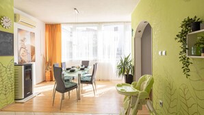 A modern kitchen with a dining area, featuring a stove, chairs, and a table set for dining. - Pet friendly apartment in Podstrana with WiFi (Podstrana)