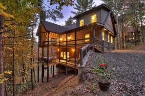A multi-level wooden cabin with a balcony, surrounded by trees. - Hunter’s Treehouse | Mtn Views + Hot Tub + Games (Epworth)